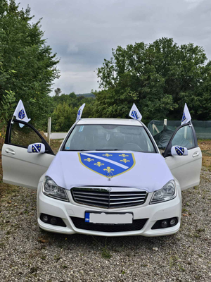Bijeli mercedes sa zastavom ljiljani