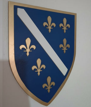 Ukrasni grb RBiH sa 6 ljiljana okacen na bijelom zidu