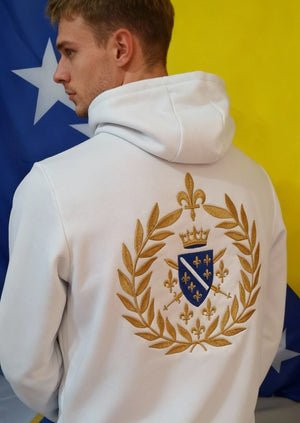 Covijek u bijeloj dukserici sa Vijencom na ledjima i zastavom BiH u pozadini