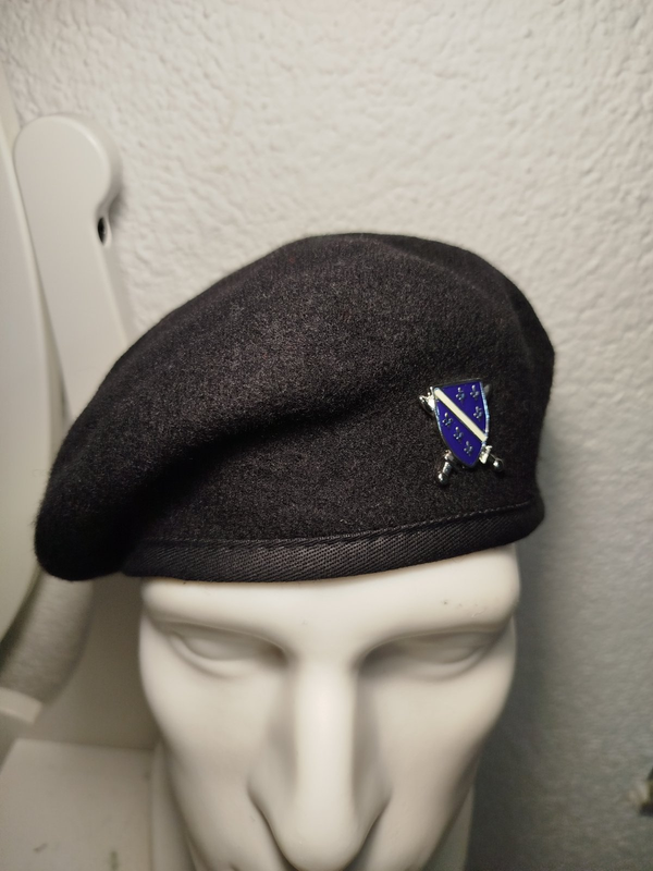 crna beretka sa grbom Armije RBIH na bijeloj glavi od lutke